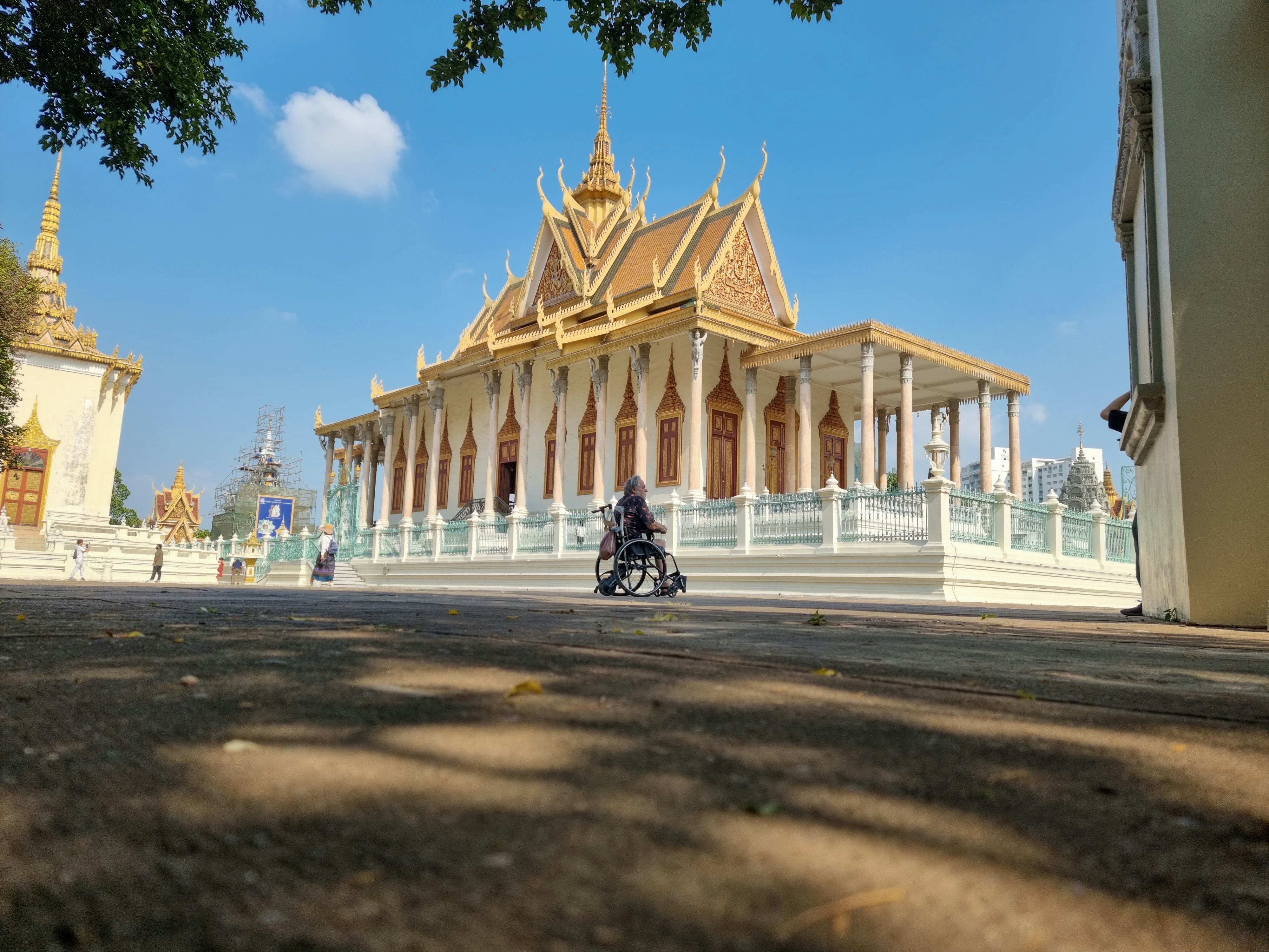 A man riding a motorcycle down a street next to a tall building