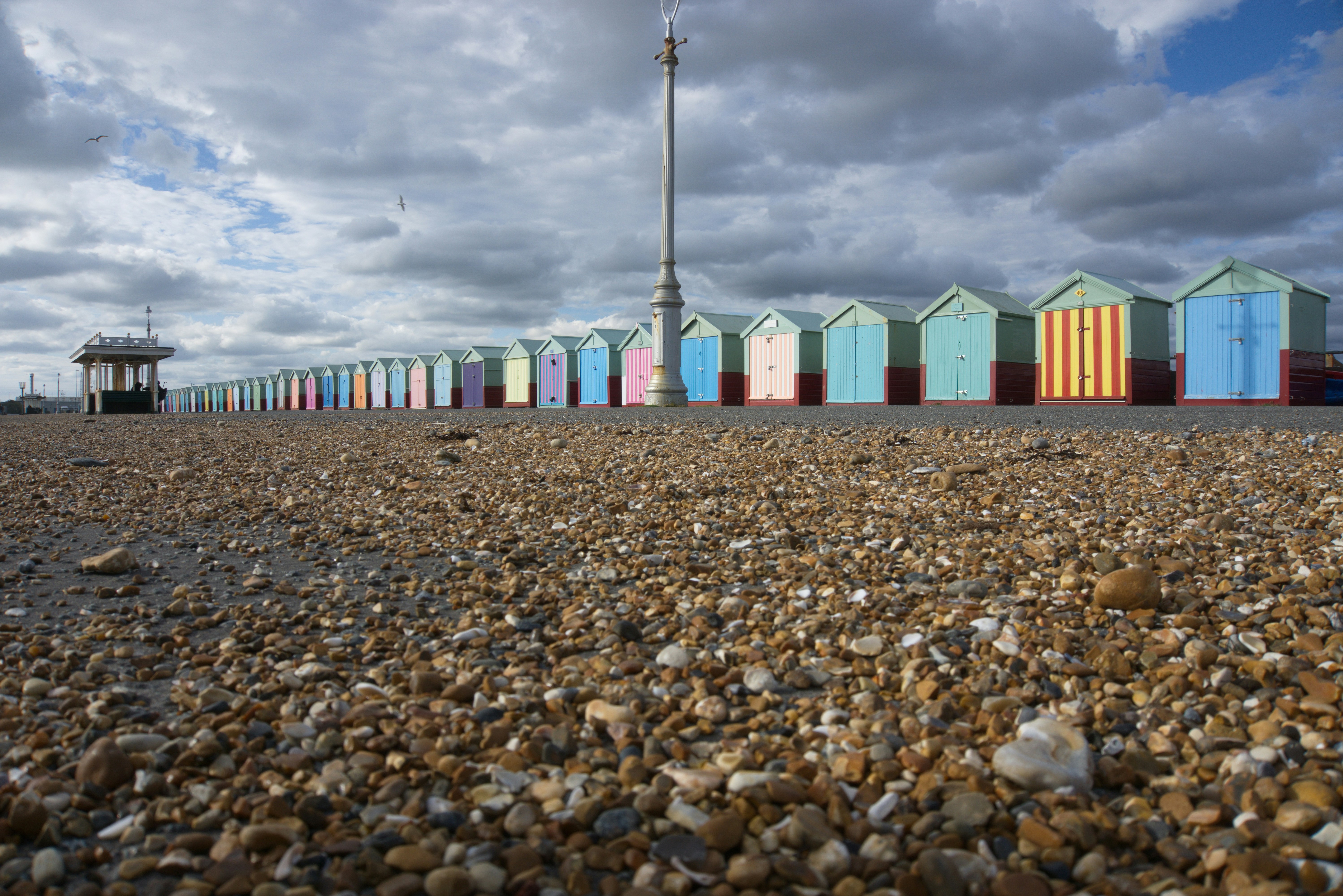 A row of colorful beach huts sitting on top of a sandy beach