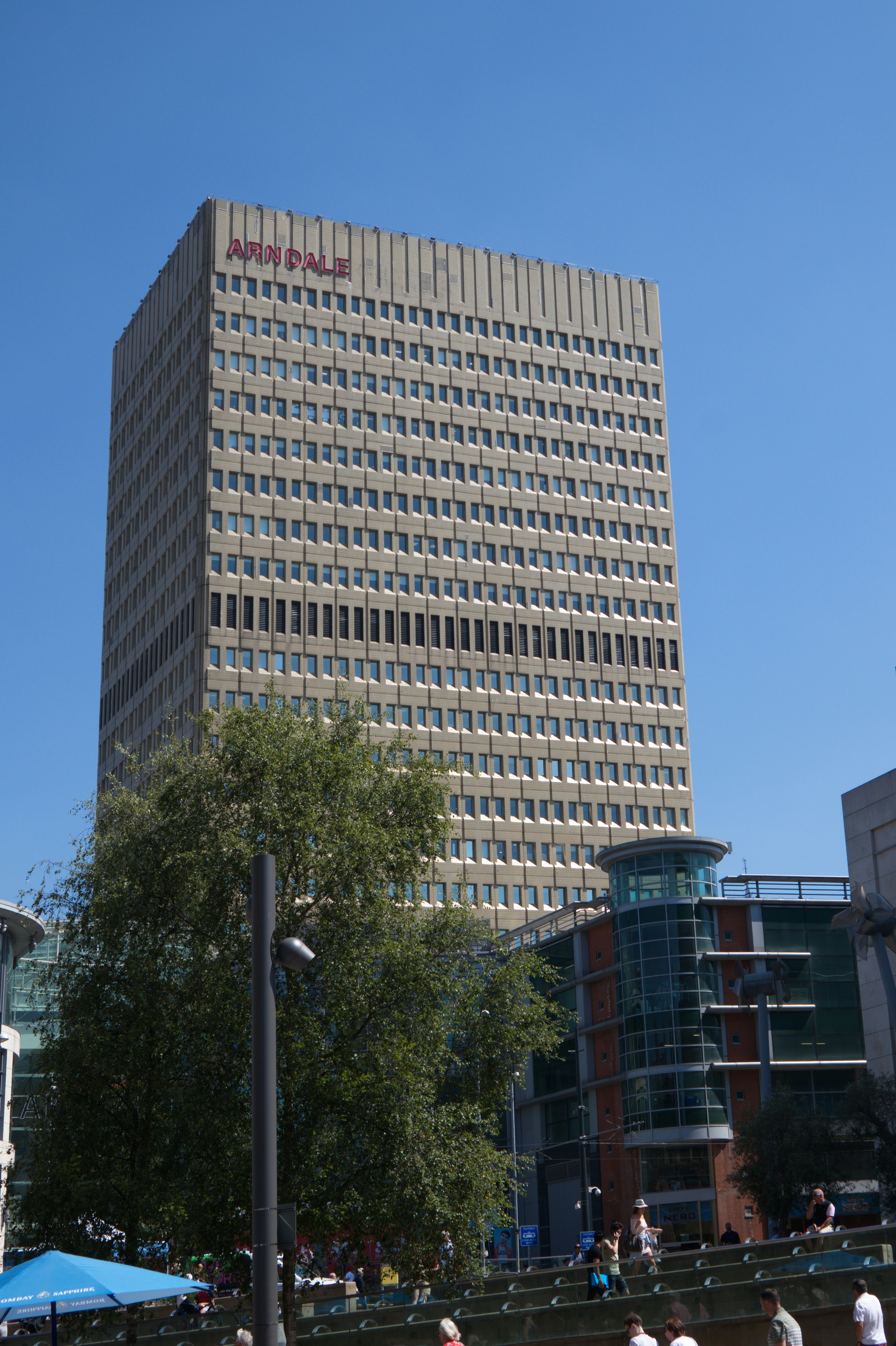 A group of people walking in front of a tall building