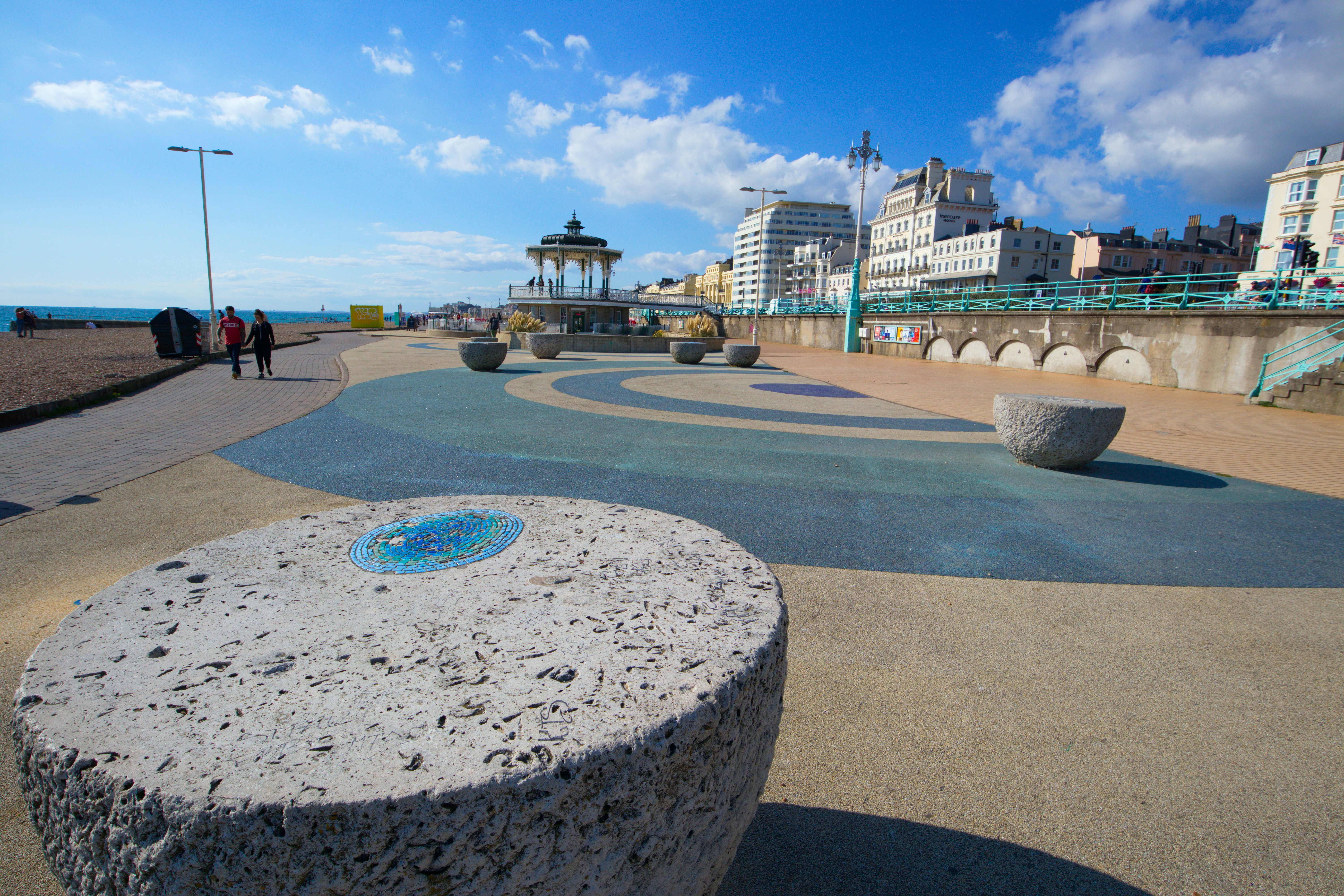 A large rock sitting on the side of a beach