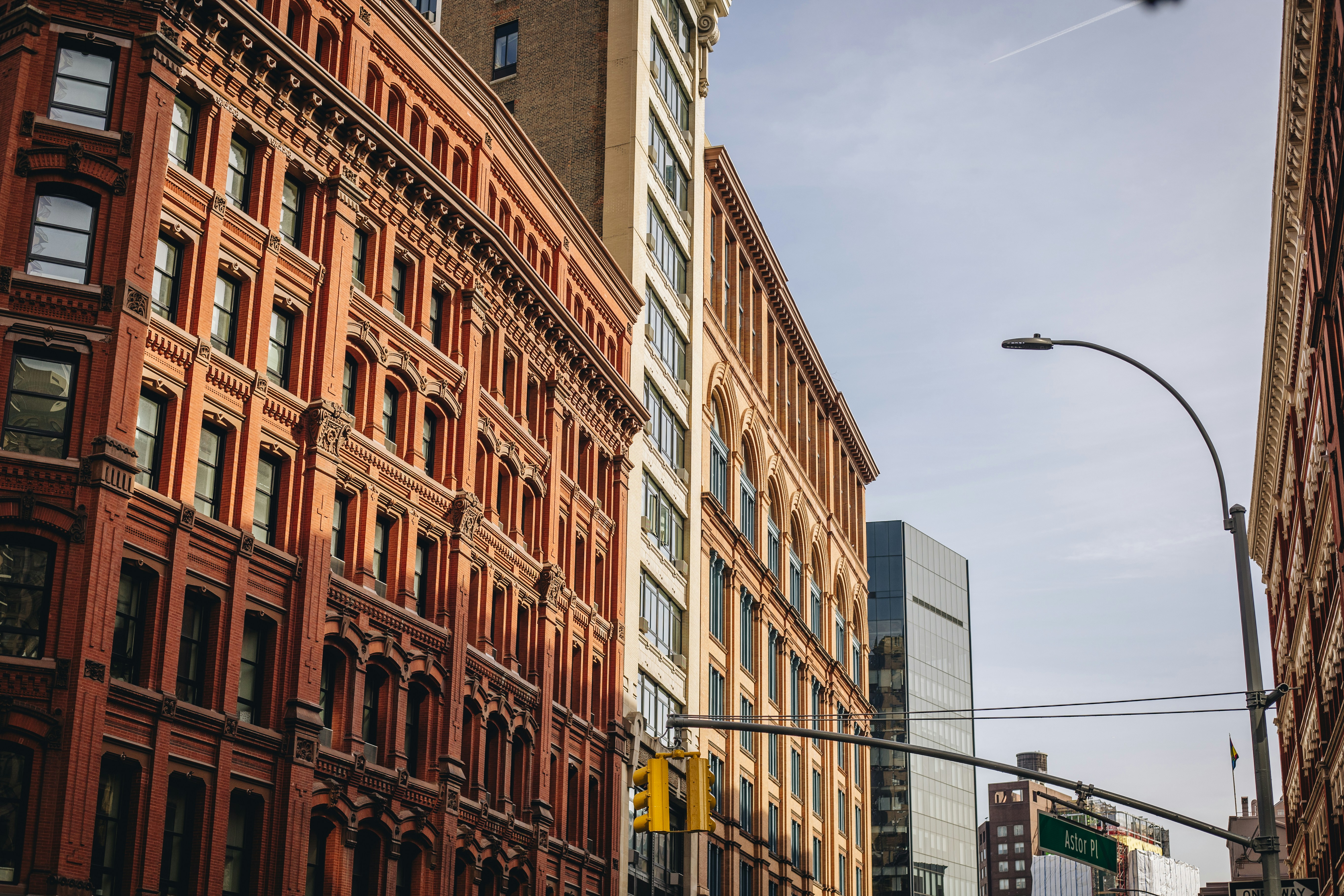 A city street filled with traffic next to tall buildings, 