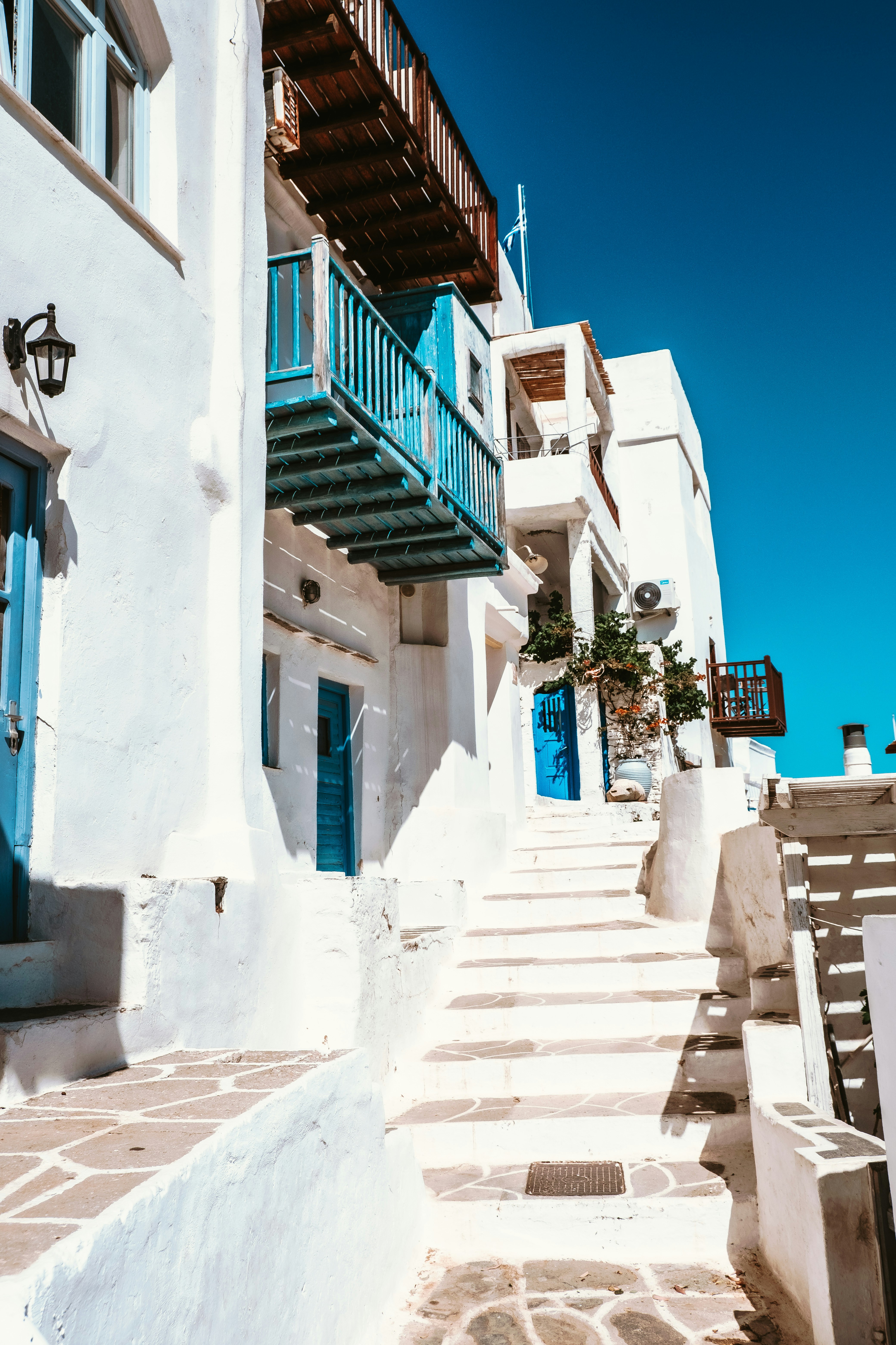 A white building with blue balconies and stairs