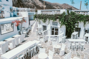 Tables and chairs outside of a restaurant with a mountain in the background
