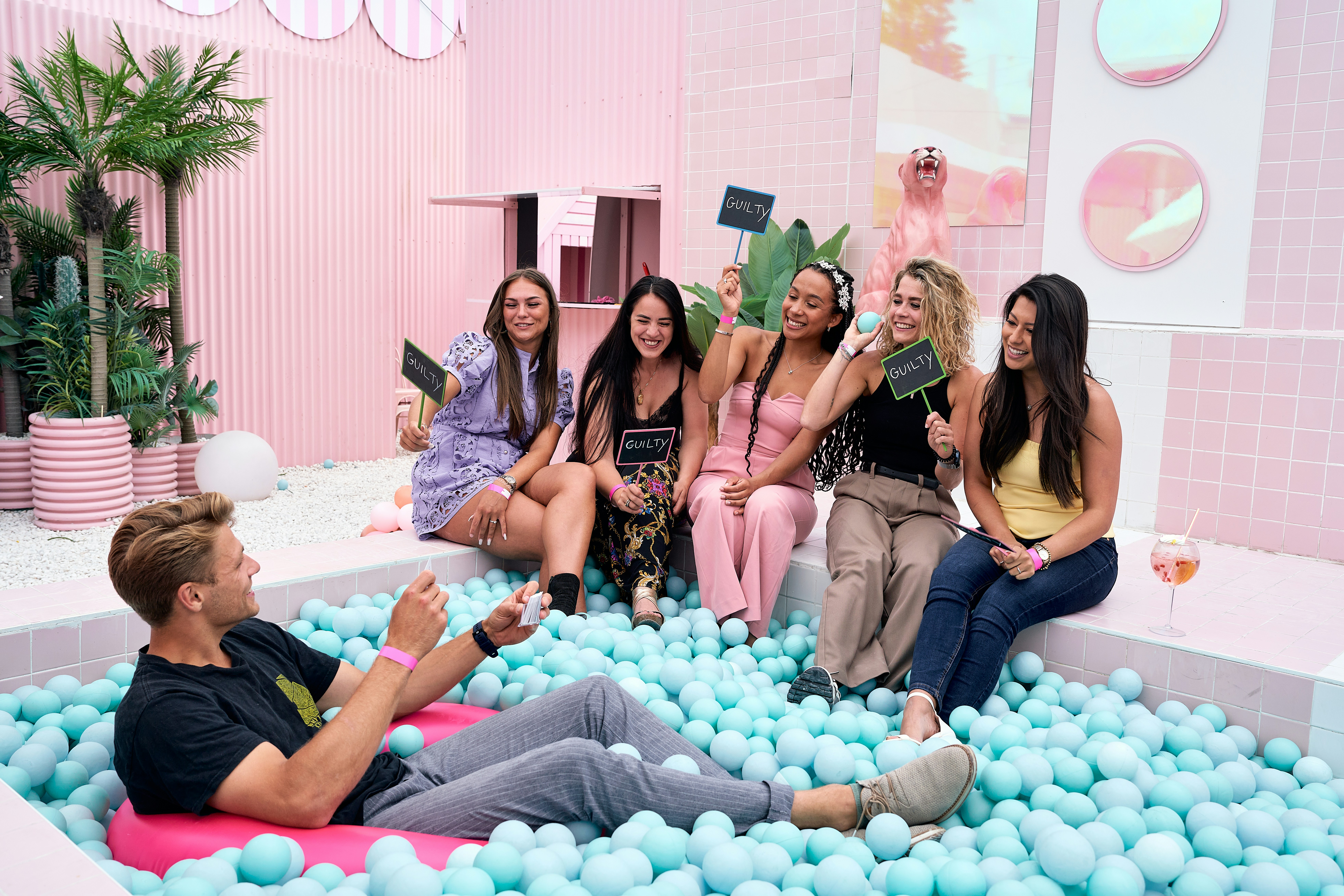 A group of people sitting in a bathtub filled with blue balls
