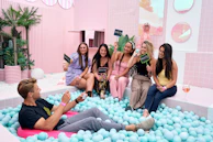 A group of people sitting in a bathtub filled with blue balls