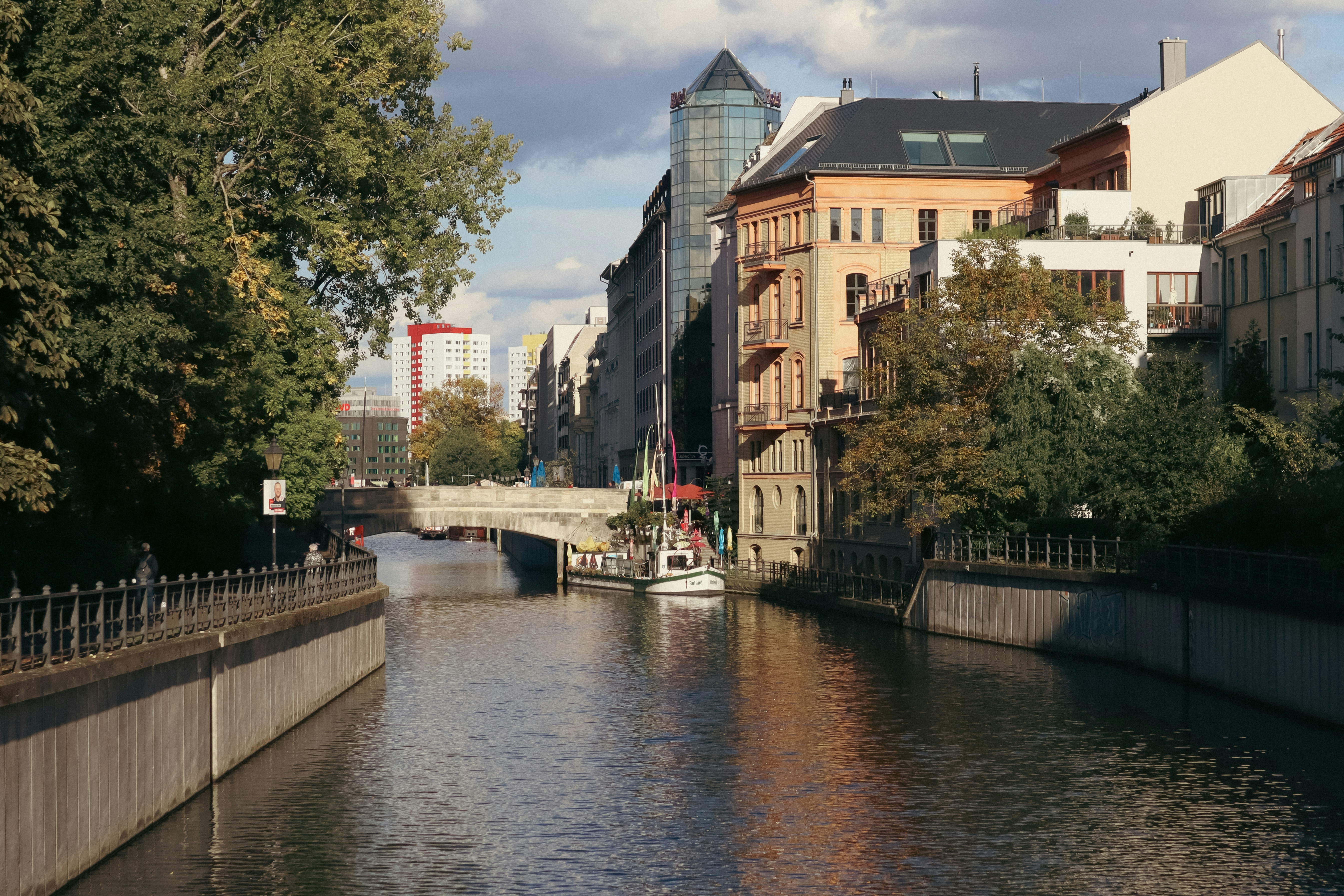 A river running through a city next to tall buildings, 