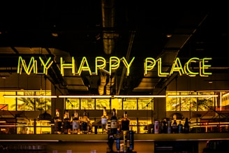 A building with a neon sign that says, my happy place