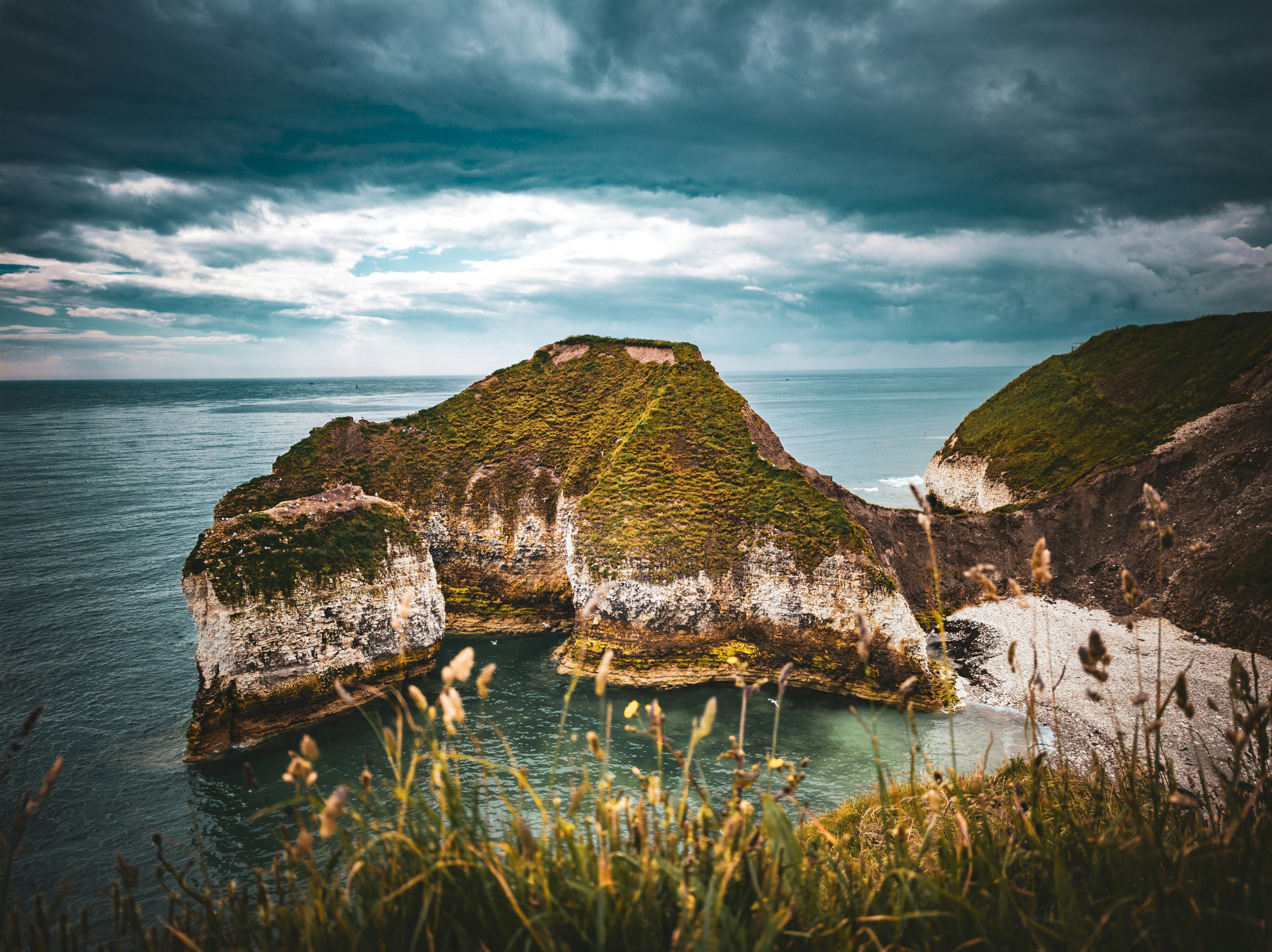 A large body of water surrounded by a lush green hillside