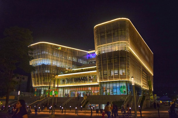 A group of people standing outside of a building at night