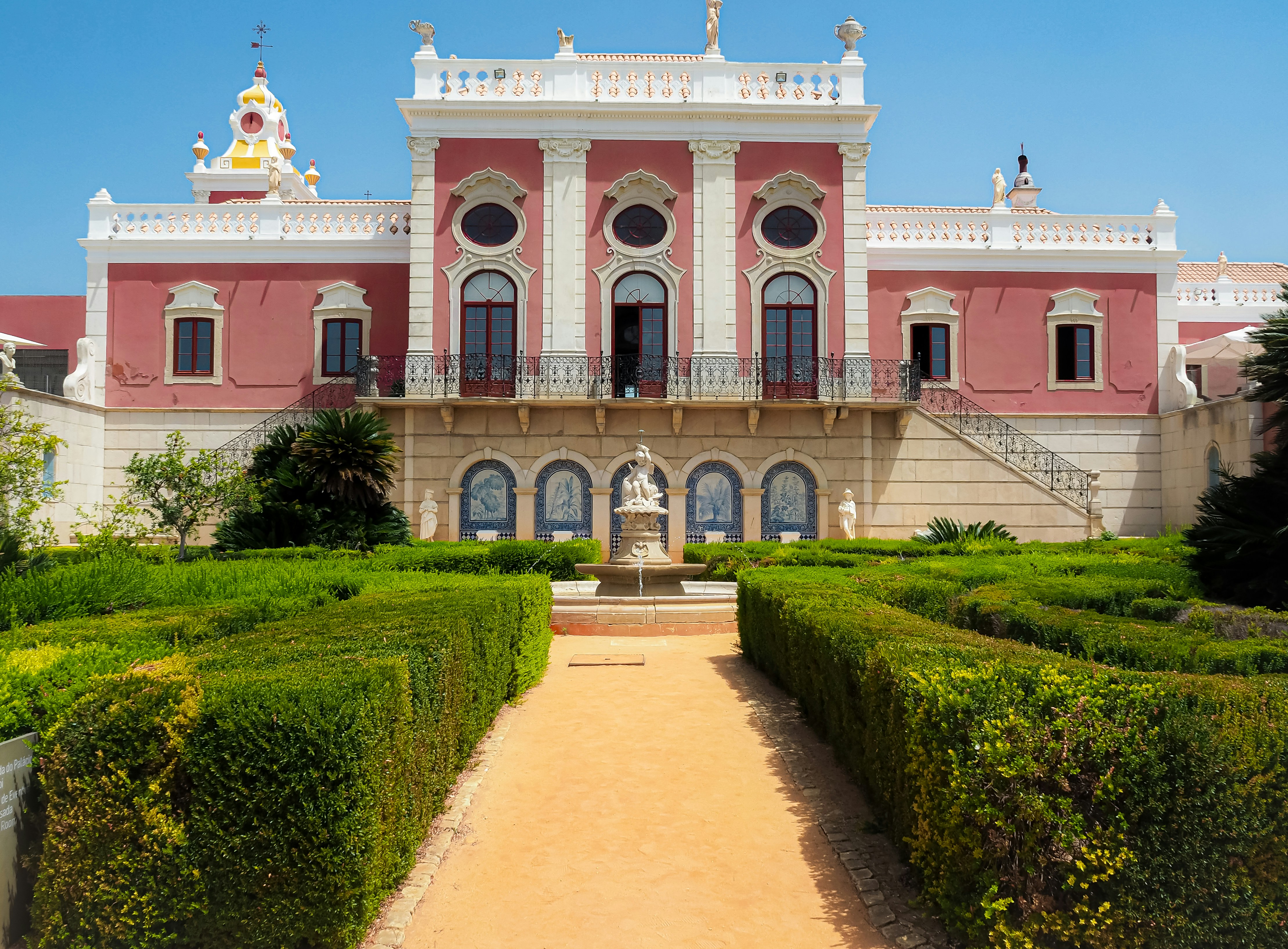 A large building with a lot of hedges in front of it