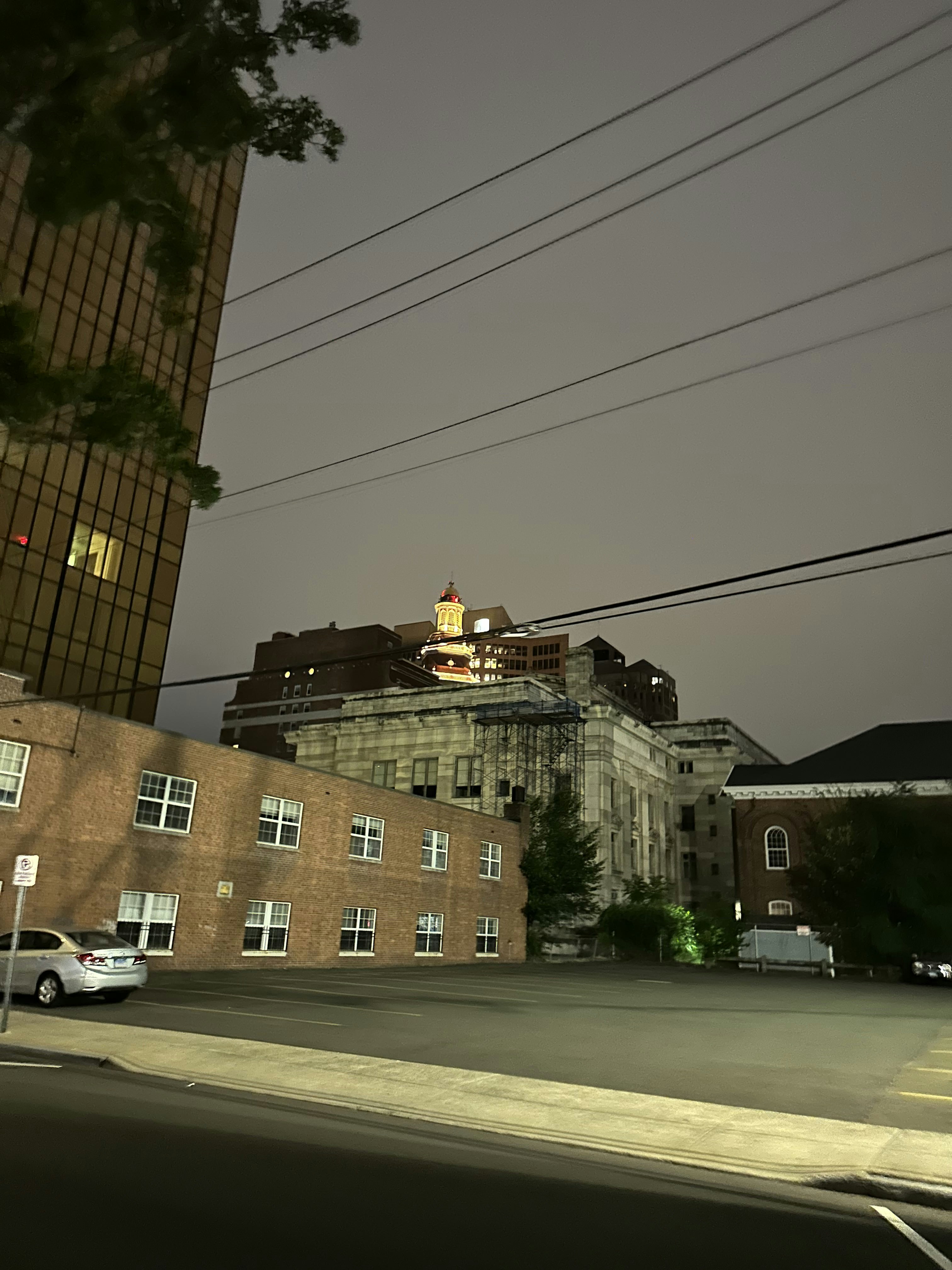 A city street at night with a building in the background