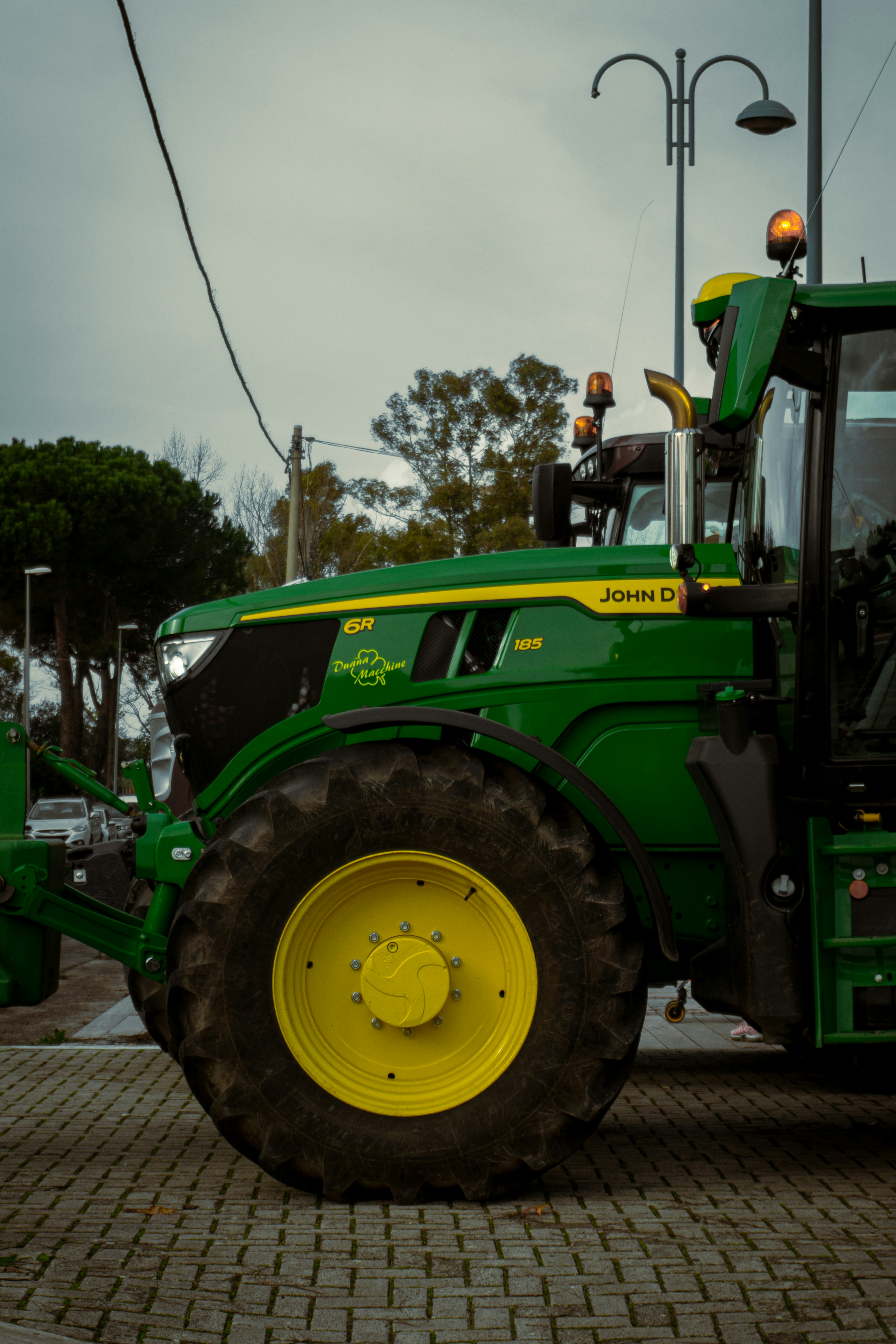 A green tractor parked on a brick road