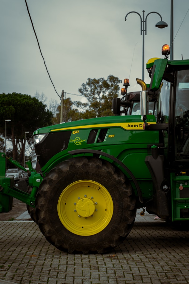 A green tractor parked on a brick road