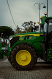 A green tractor parked on a brick road