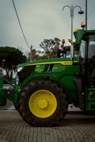 A green tractor parked on a brick road