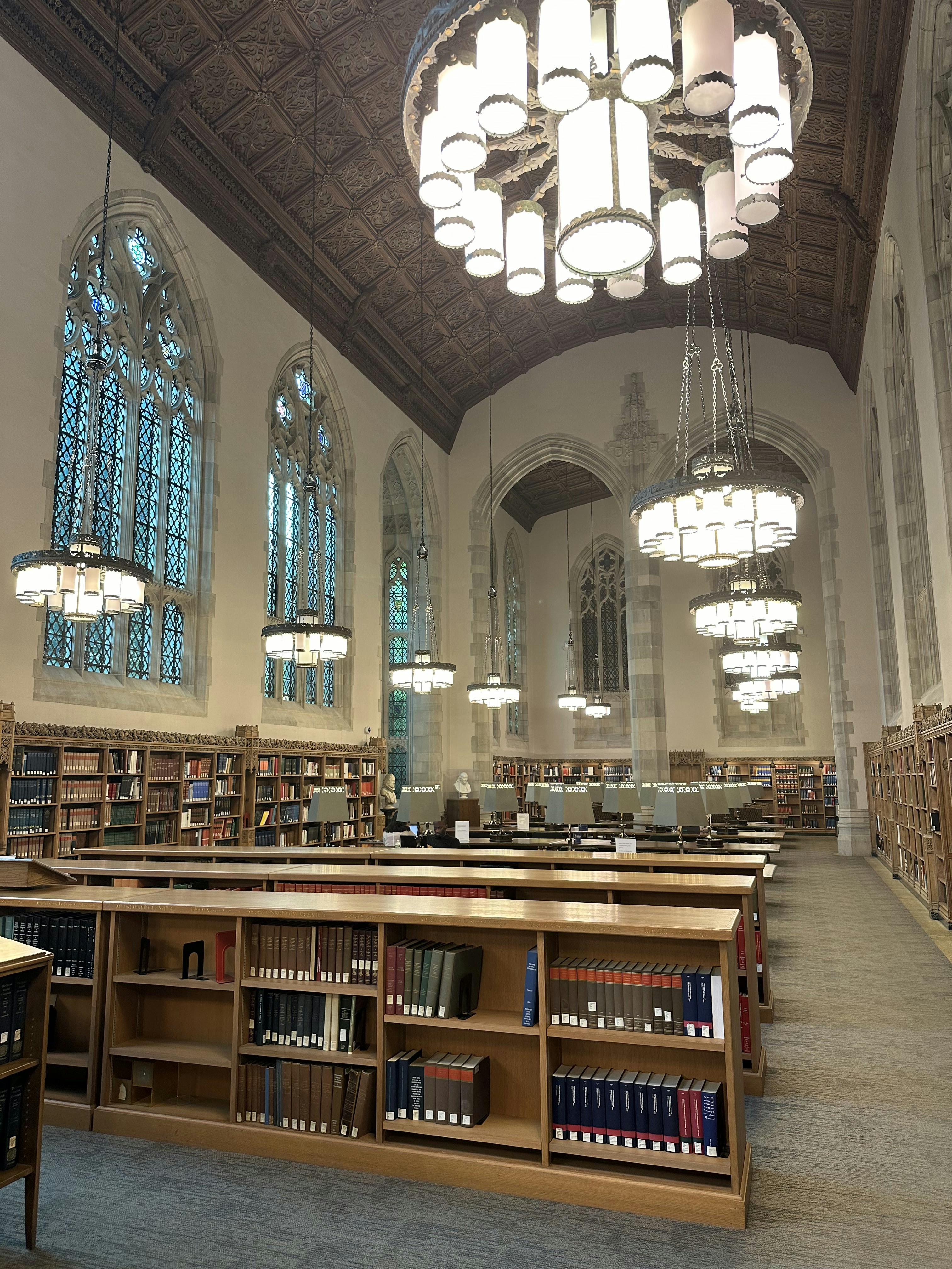 A large library with a chandelier hanging from the ceiling