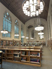 A large library with a chandelier hanging from the ceiling