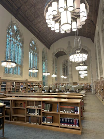 A large library with a chandelier hanging from the ceiling