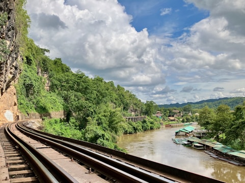 A train traveling down tracks next to a river