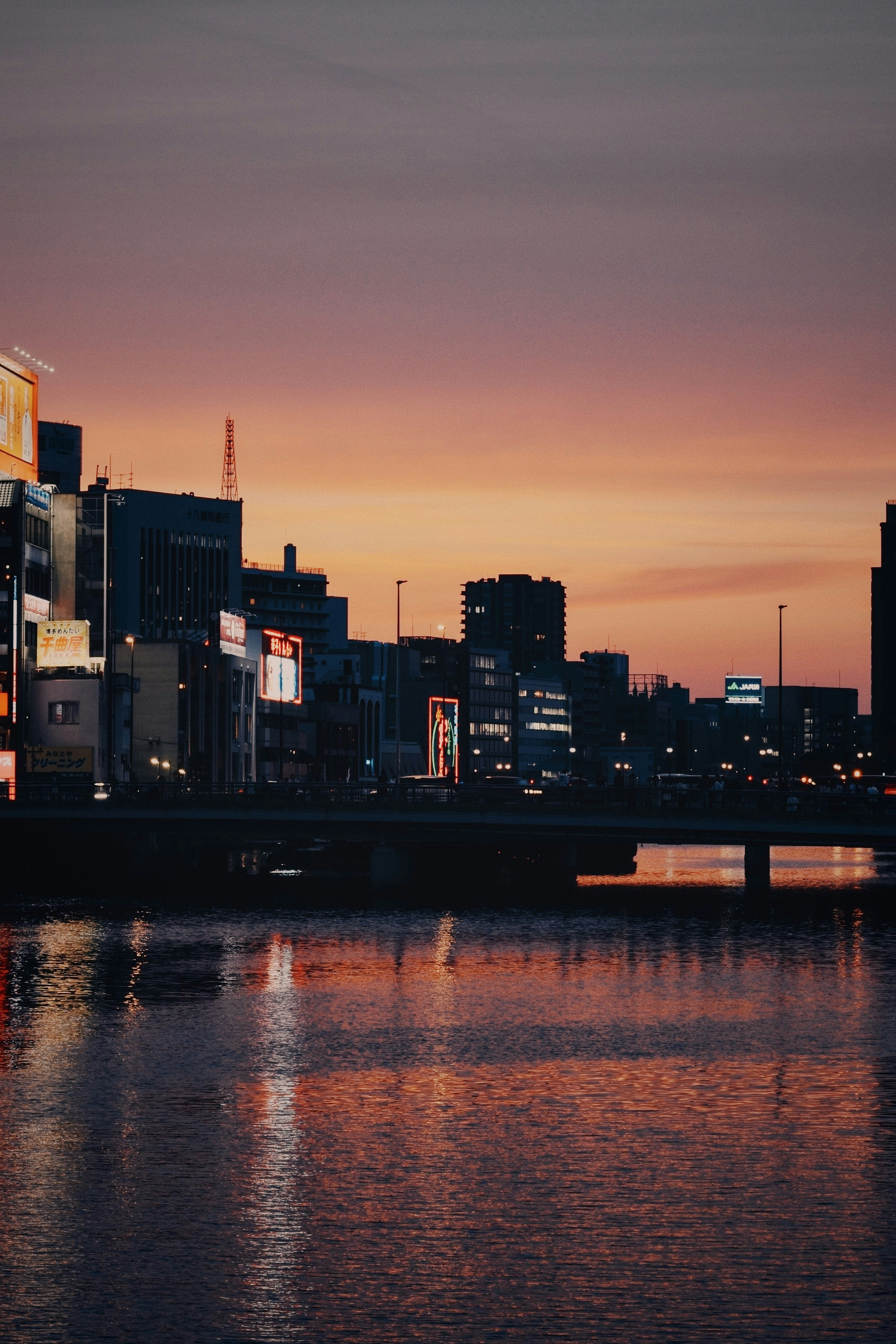 A city skyline with a bridge over a body of water