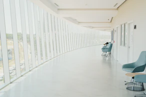 A long hallway with a row of chairs next to a wall