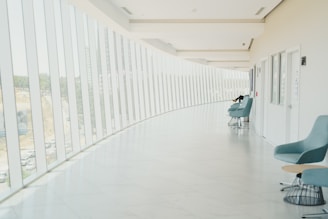 A long hallway with a row of chairs next to a wall