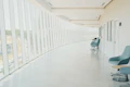 A long hallway with a row of chairs next to a wall