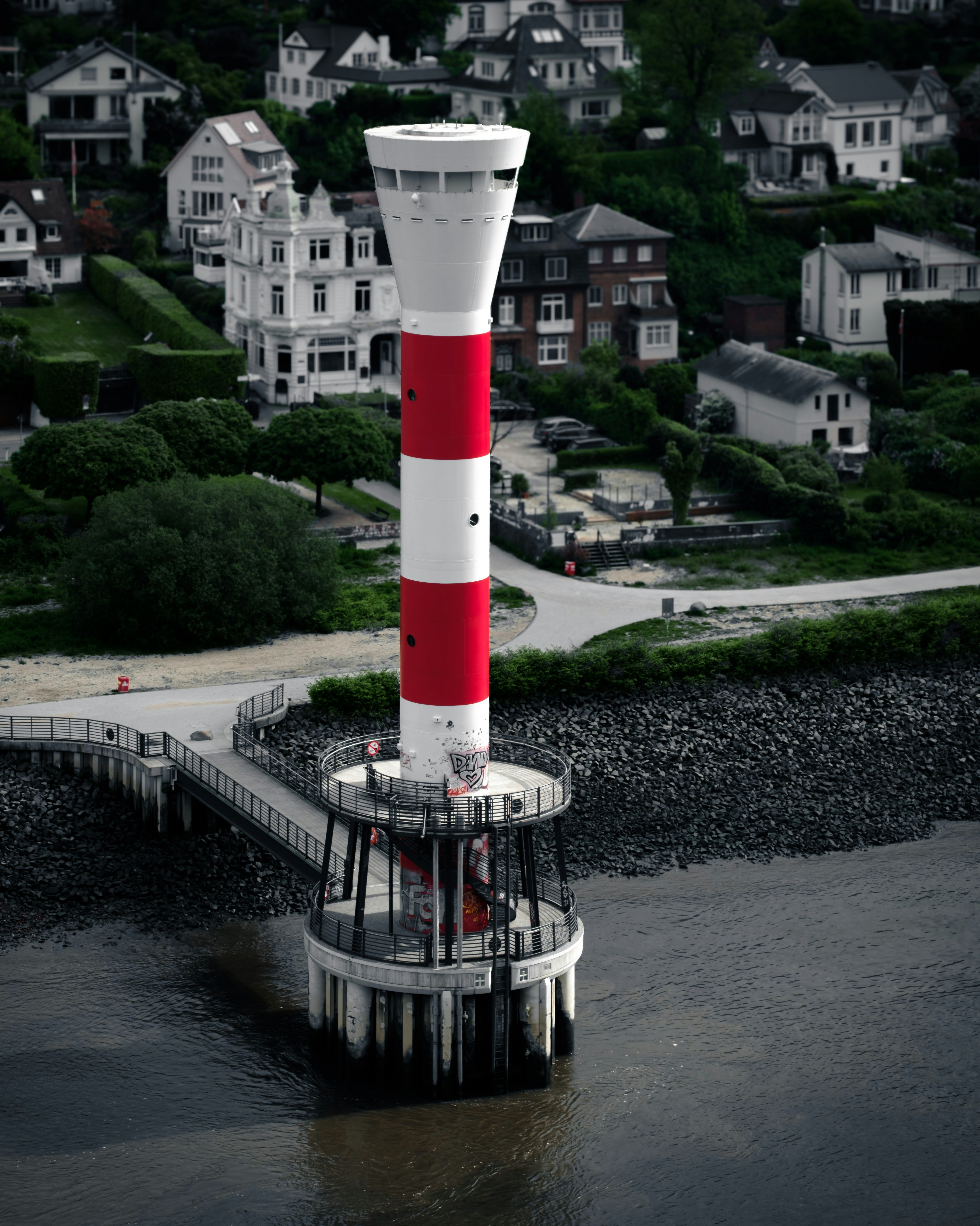 A red and white lighthouse sitting on top of a body of water