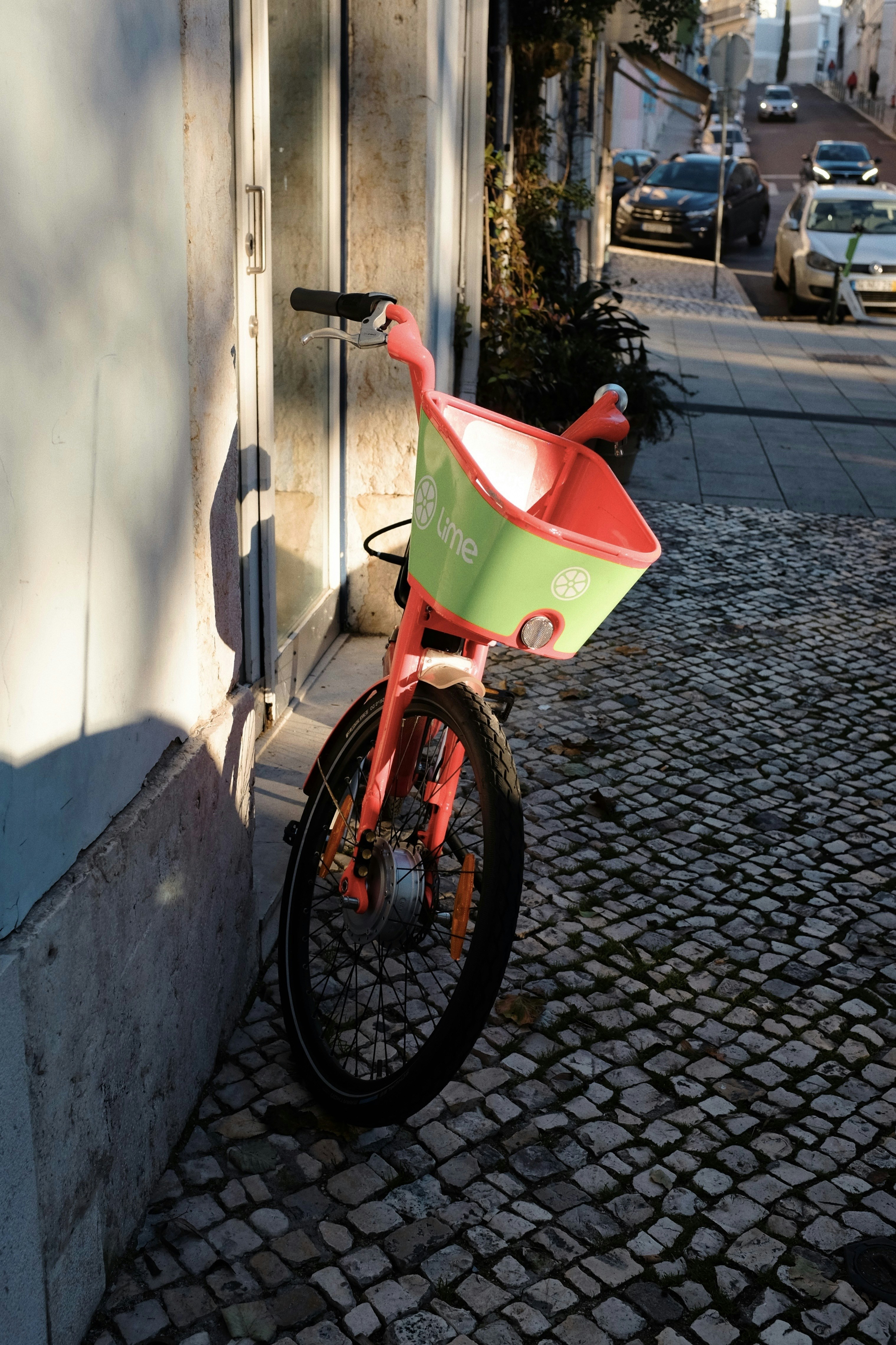 A red and green bike parked next to a building