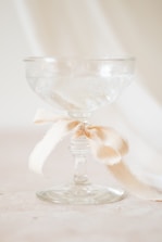 A glass with a bow on it sitting on a table