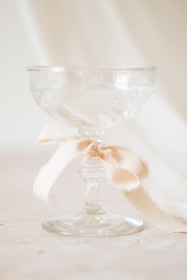 A glass with a bow on it sitting on a table