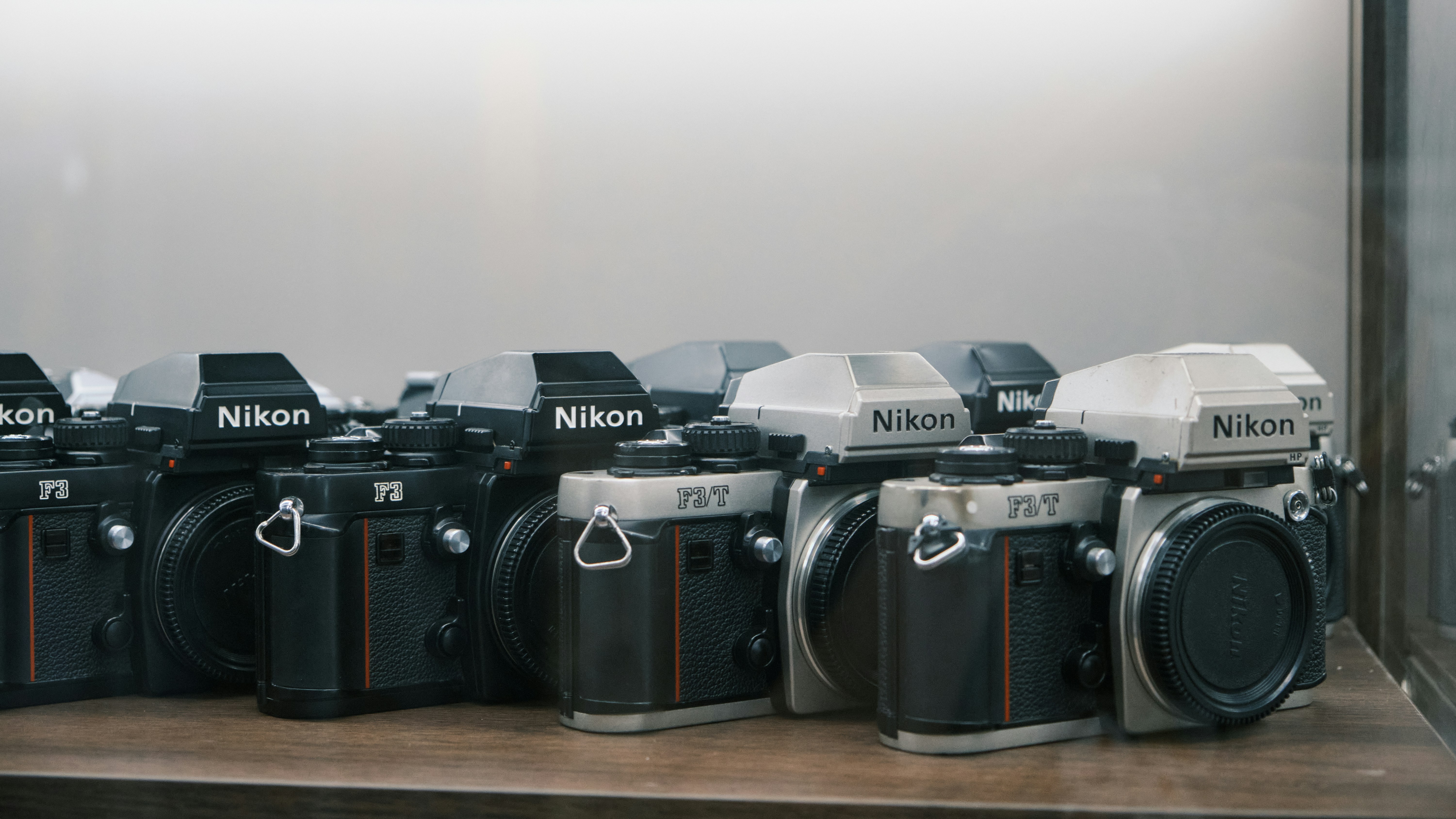 Un groupe de caméras posées sur une étagère en bois