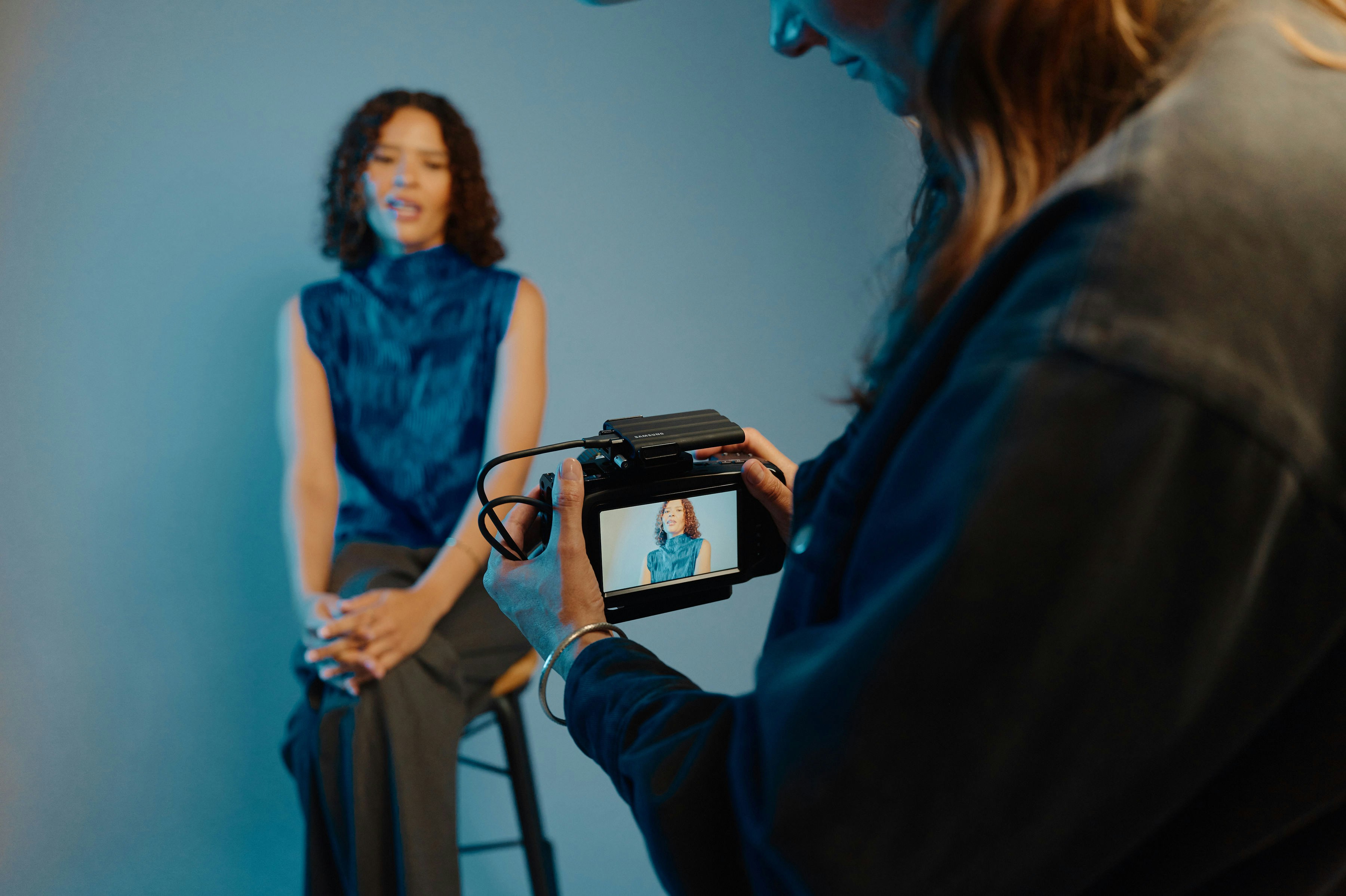 A woman holding a camera in front of a mirror