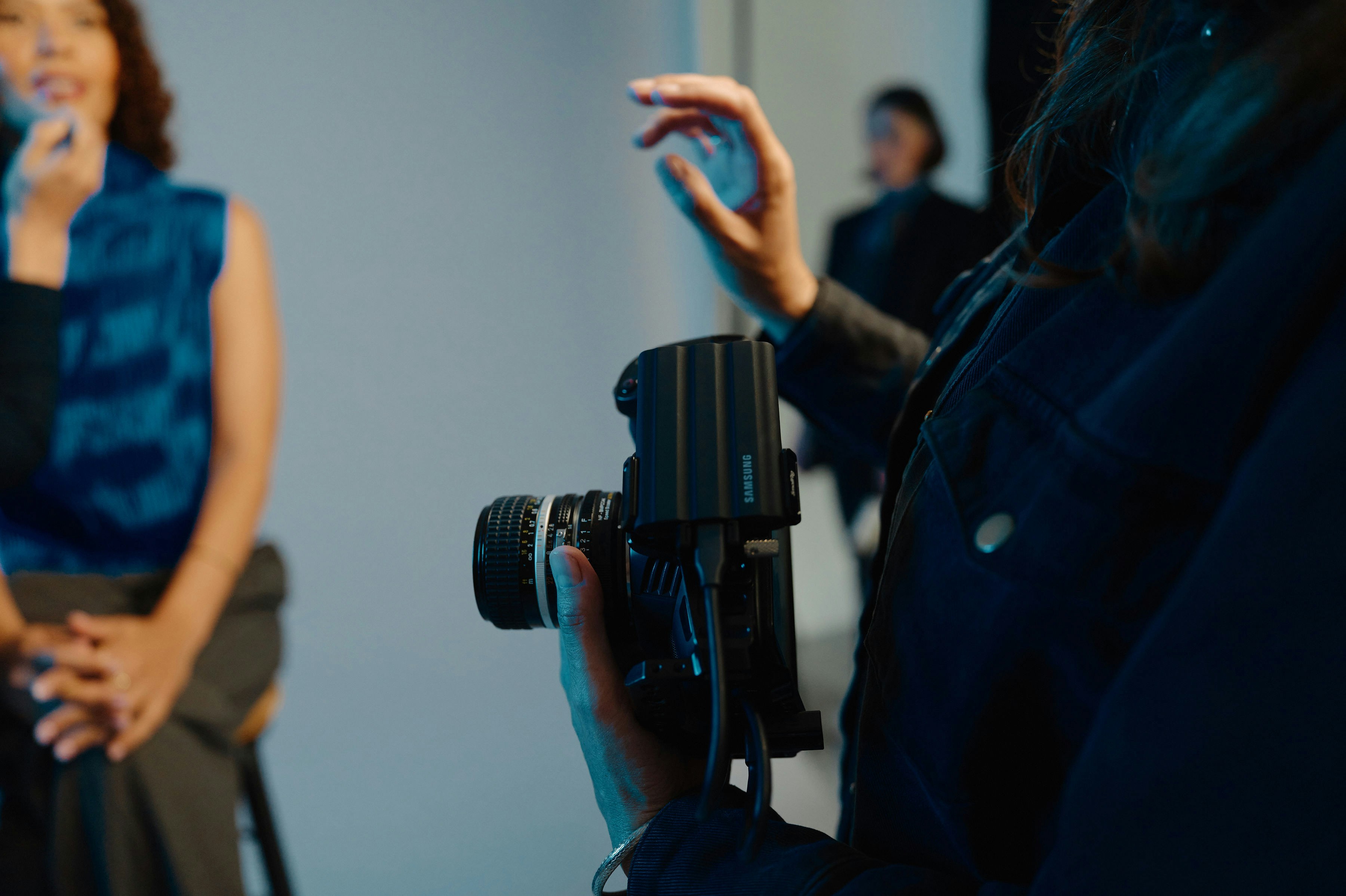 A woman standing in front of a camera holding a microphone