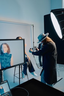 A man is filming a woman in a blue dress