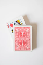 A red playing card sitting on top of a white table