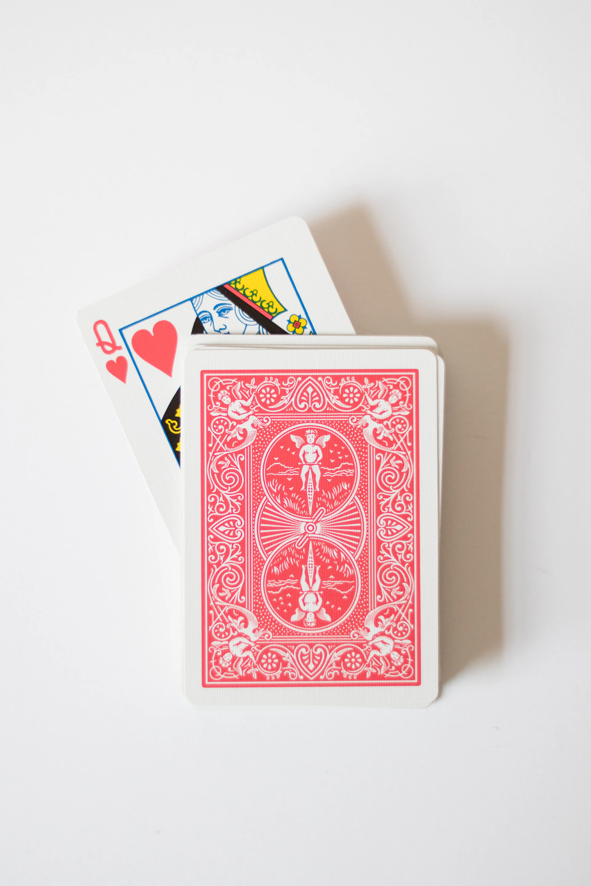 A red playing card sitting on top of a white table