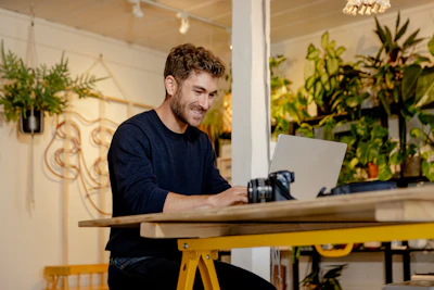 A man sitting at a table using a laptop computer