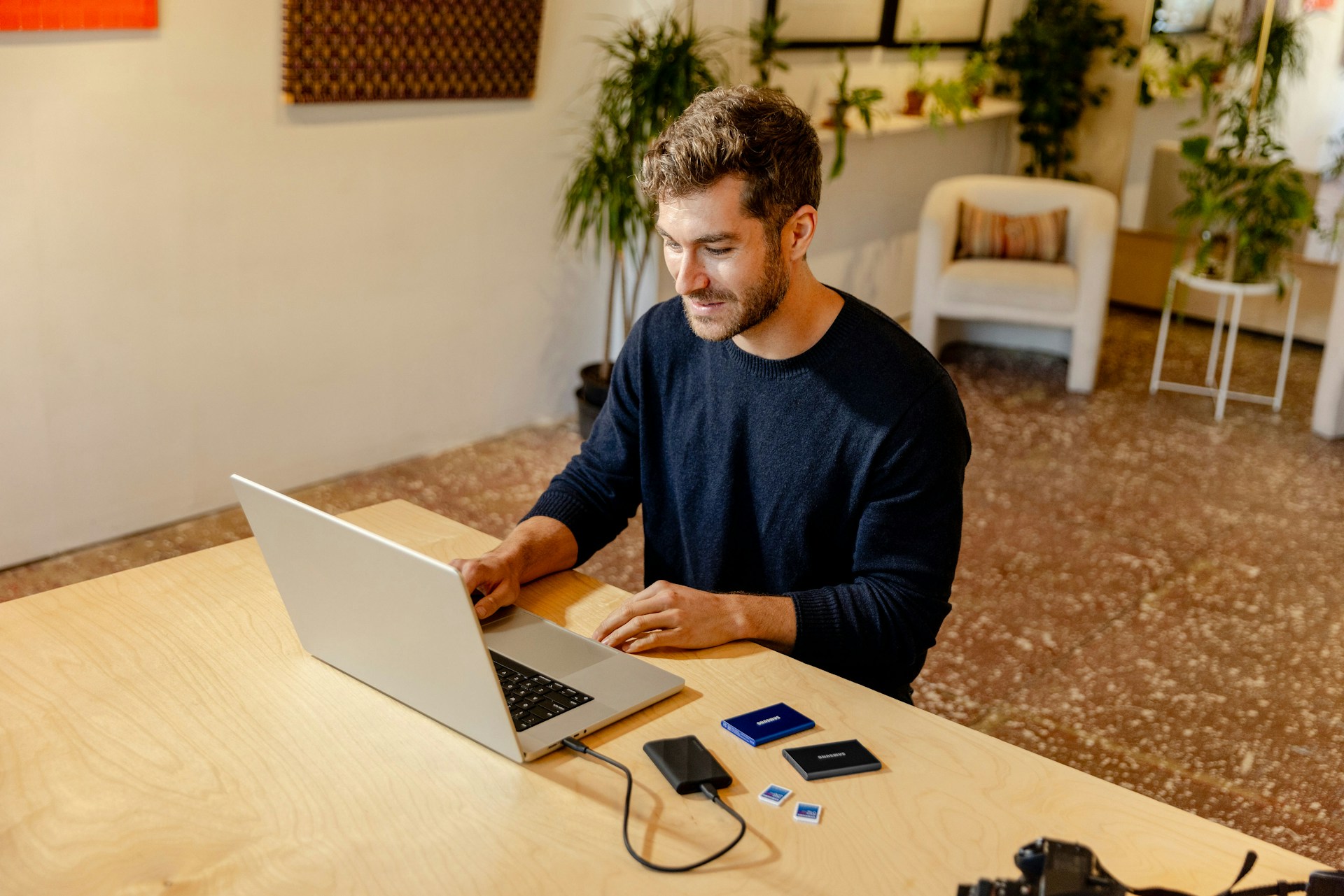 A man sitting at a table using a laptop computer