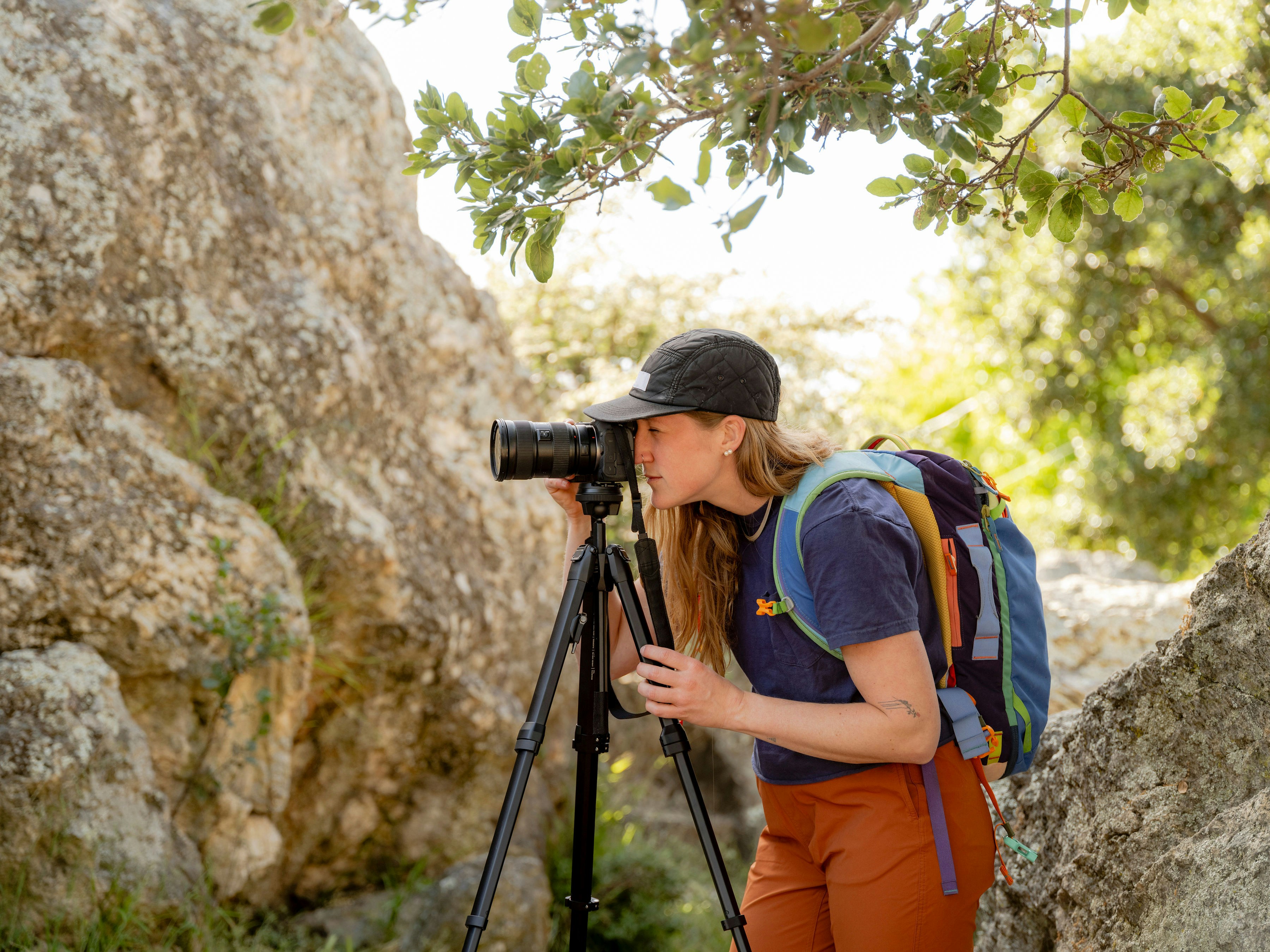 A woman taking a picture of a rock with a camera