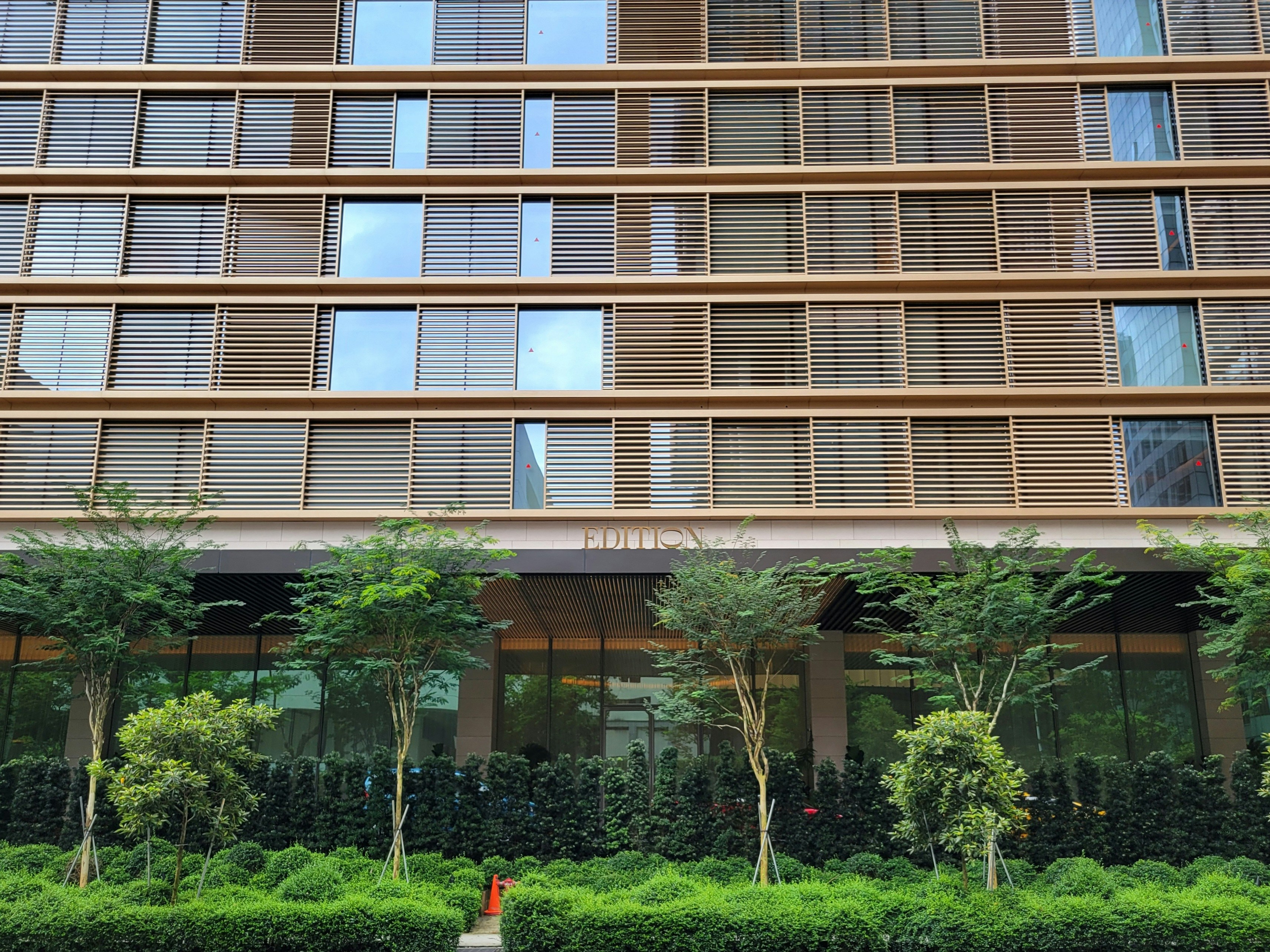 A tall building with lots of windows next to a street