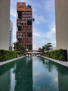 A long pool in front of a tall building