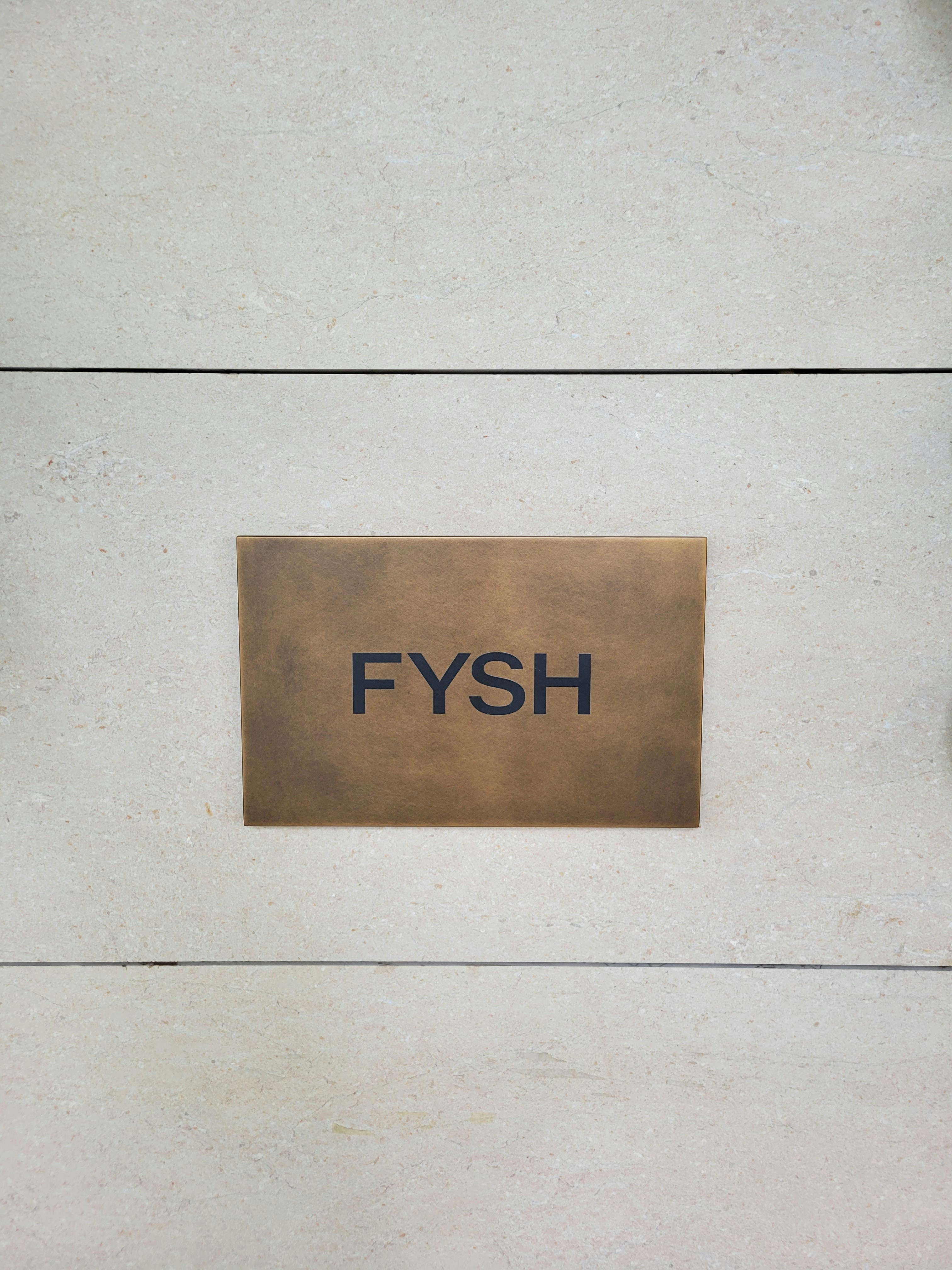 A sign that says fysh on the side of a building