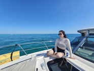 A woman sitting on a boat in the ocean