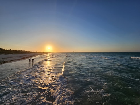 El sol se está poniendo sobre el agua en la playa
