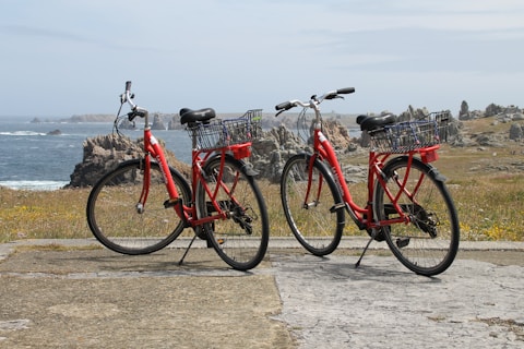 Two red bikes parked next to each other