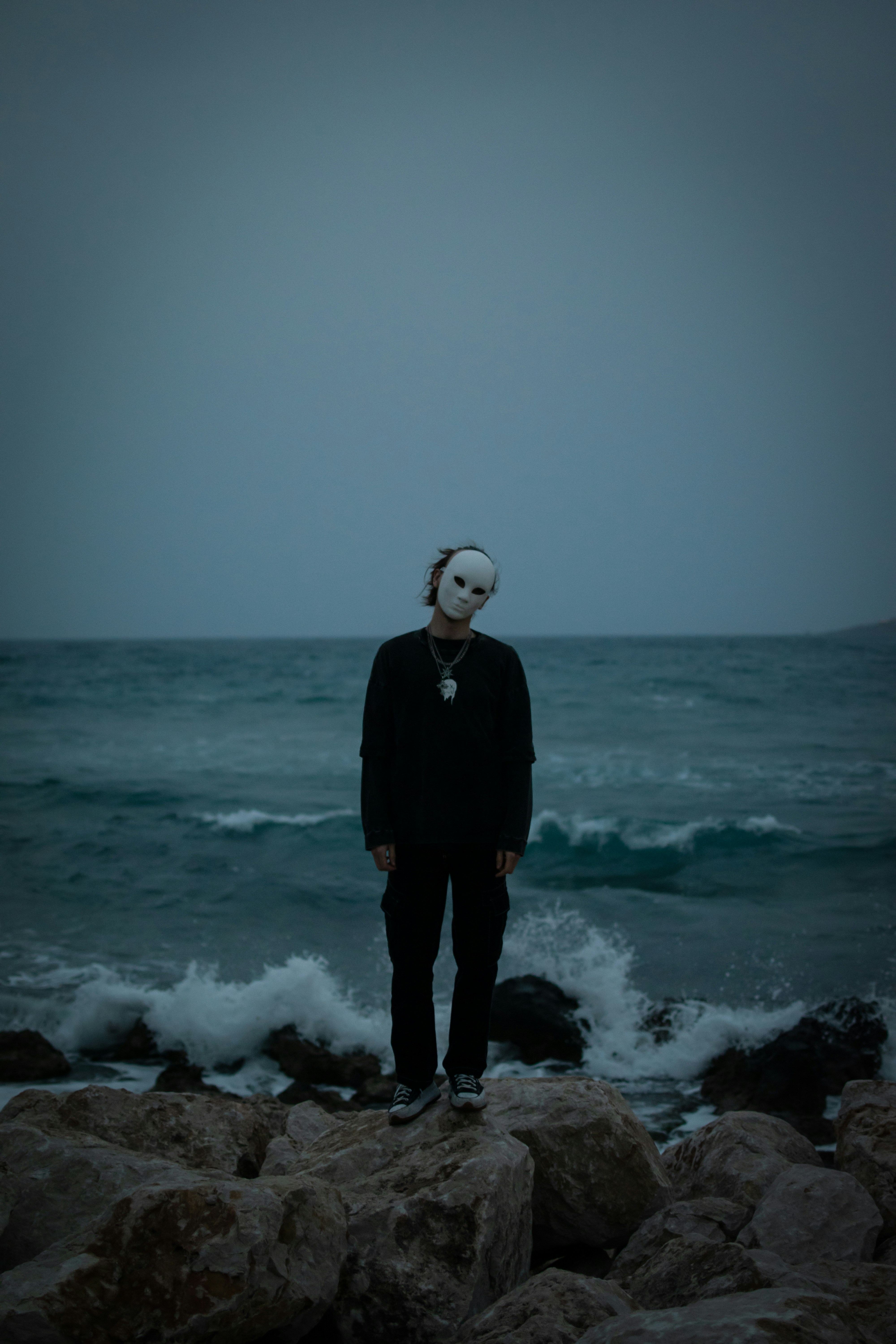 Eine Person, die auf Felsen in der Nähe des Ozeans steht