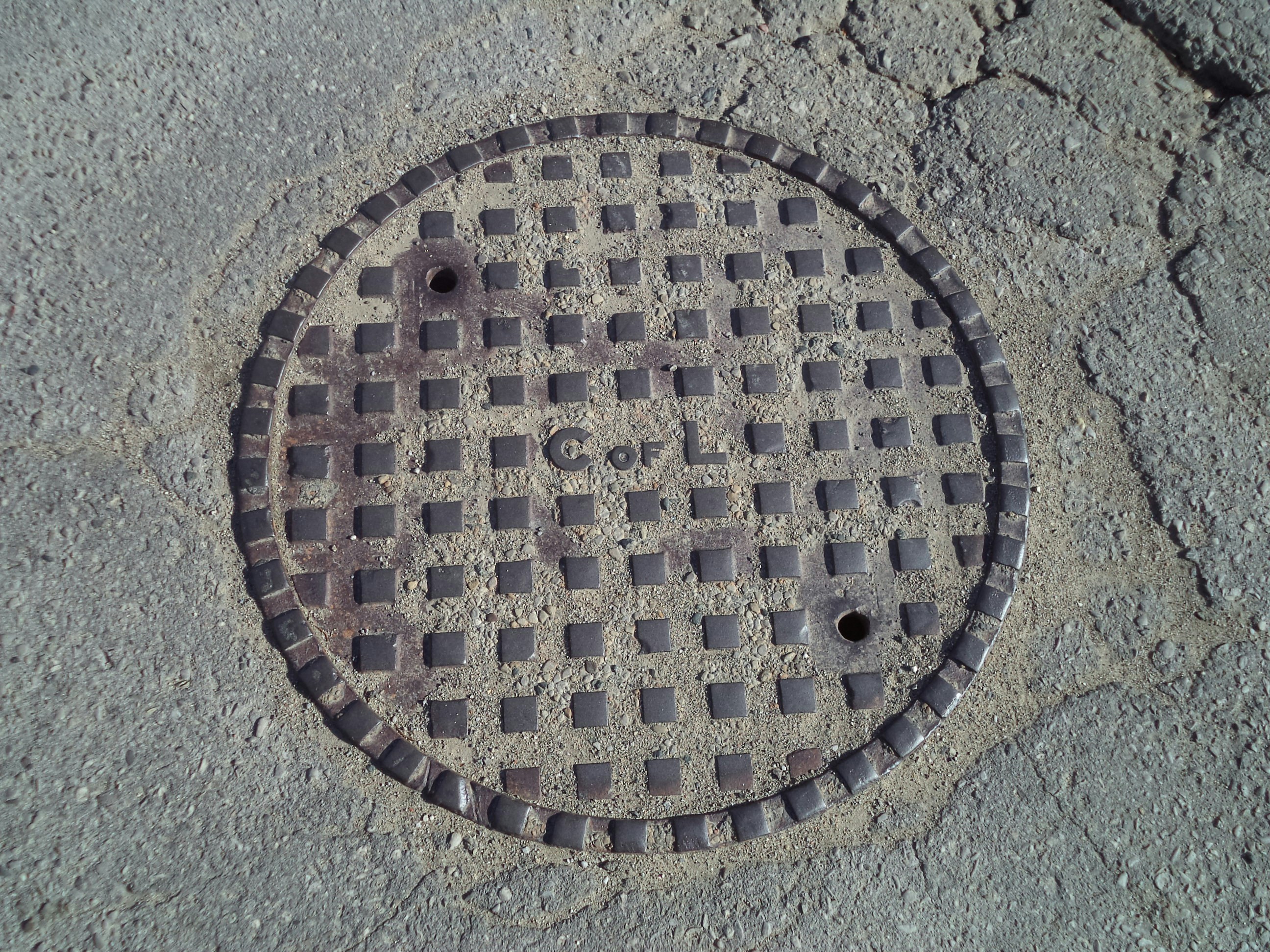 Concrete manhole cover installed in a road