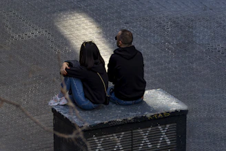 A couple of people sitting on top of a bench