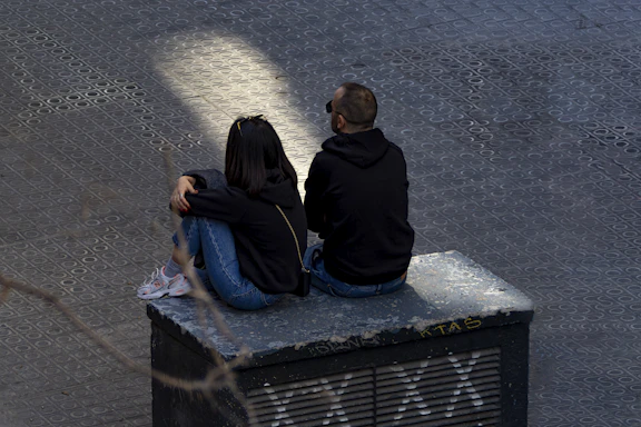 A couple of people sitting on top of a bench